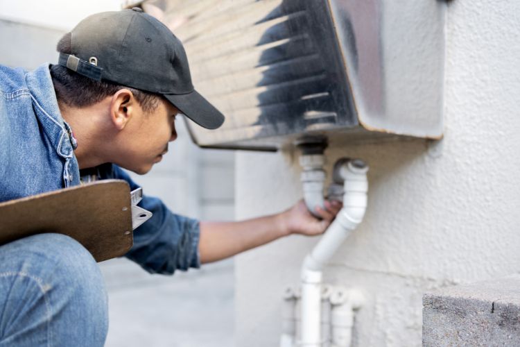 Property Owner With Checklist Inspecting Plumbing